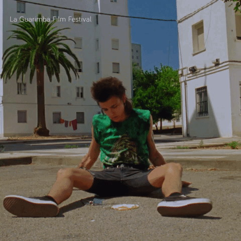 Man Sits On Gound Under Hot Sun GIF