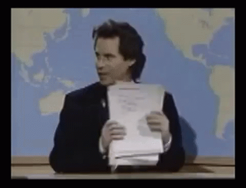 Man Sitting At Desk Holding Paper GIF