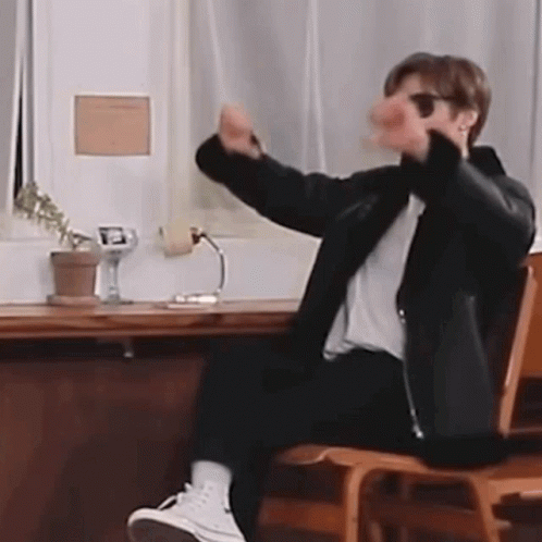 Man Sitting at Desk with Arms Outstretched