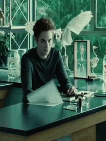 Man Sitting at Desk with Bird in Glass Case