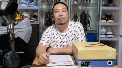 Man Sitting at Desk With Box of Air Jordans