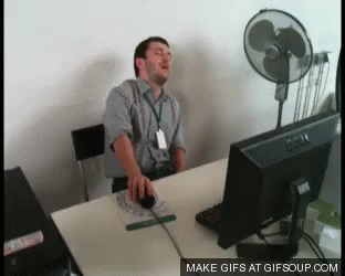 Man Sitting at Desk with Computer and Fan