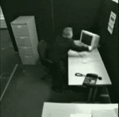 Man Sitting at Desk With Computer and Phone