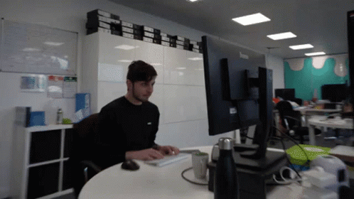 Man Sitting At Desk With Lenovo Monitor GIF