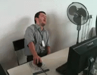 Man Sitting At Desk With Mouse And Fan GIF