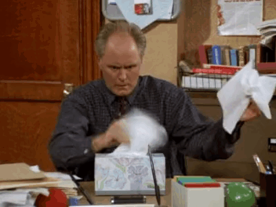 Man Sitting at Desk With Tissues