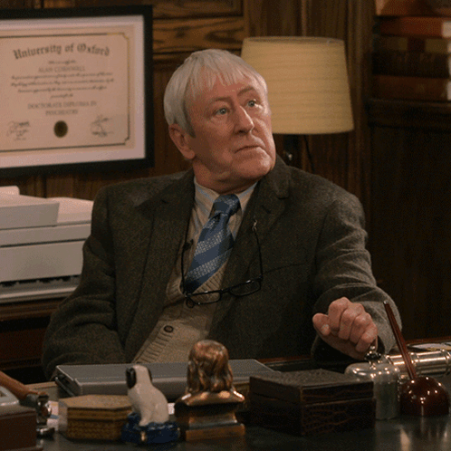 Man Sitting at Desk With University of Oxford Diploma