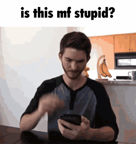 Man Sitting At Table Looking At Cell Phone GIF