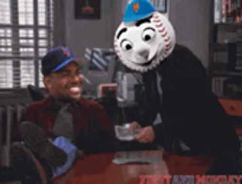 Man Sitting at Table with Baseball Mask