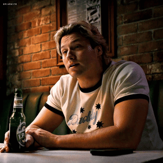 Man Sitting at Table with Beer Bottle