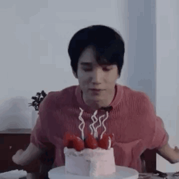 Man Sitting at Table with Cake and Candles