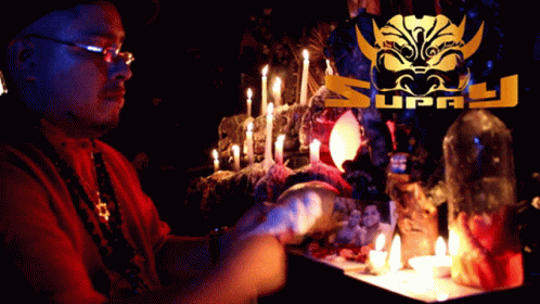 Man Sitting at Table with Candles and Supply Logo
