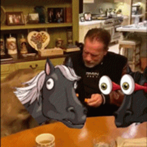 Man Sitting At Table With Cartoon Horse Head GIF