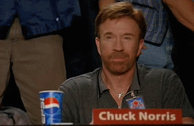 Man Sitting at Table With Chuck Norris Sign