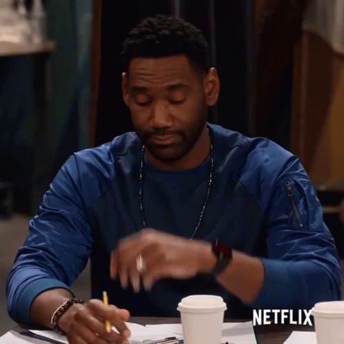 Man Sitting at Table with Coffee and Netflix Logo
