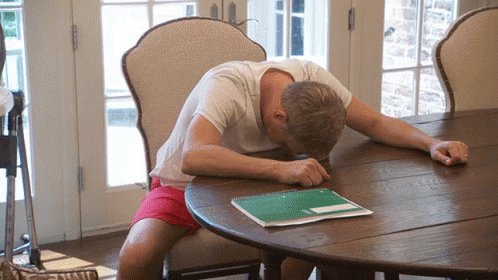 Man Sitting At Table With Head On Notebook GIF