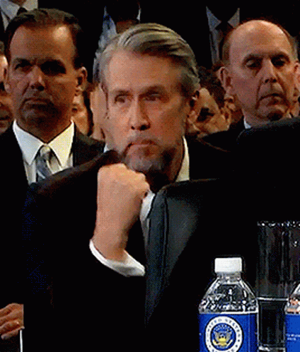 Man Sitting At Table With Lamp And Flowers GIF