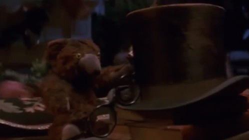 Man Sitting at Table With Lamp and Stuffed Animal