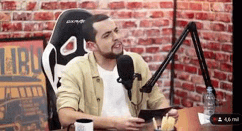 Man Sitting at Table with Microphone