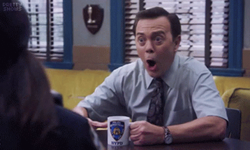 Man Sitting At Table With NYPD Mug GIF
