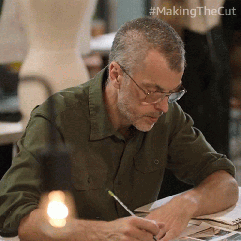Man Sitting At Table With Pencil GIF