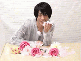 Man Sitting at Table with Pink Flowers
