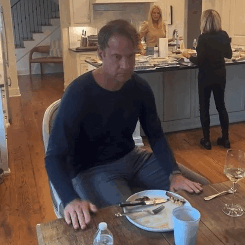Man Sitting at Table With Plate of Food