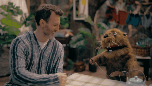 Man Sitting at Table with Stuffed Beaver