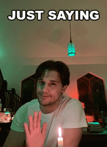 Man Sitting by Lit Candle Saying Just
