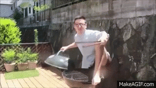 Man Sitting Crossed Legs On Grill With Wooden Stick GIF
