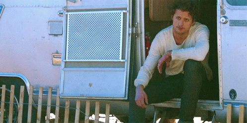 Man Sitting in Airstream Camper Doorway