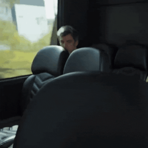 Man Sitting in Bus Looking Out Window