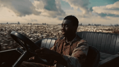 Man Sitting in Car Near Cotton Field