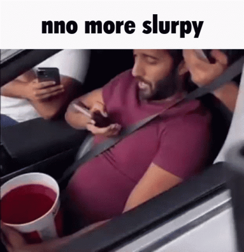 Man Sitting in Car on Phone Holding Red Drink