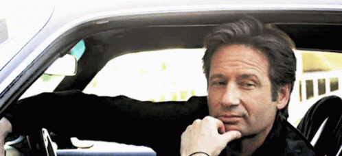 Man Sitting in Car With Hand to Chin