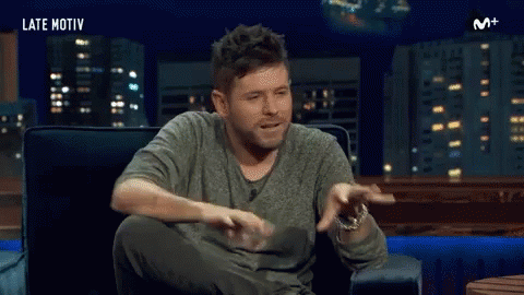 Man Sitting In Chair Arms Outstretched Mouth Open GIF