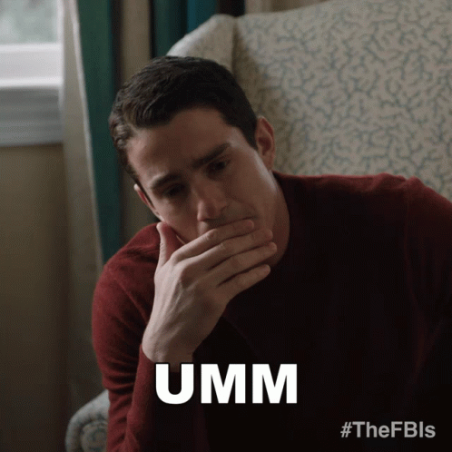 Man Sitting in Chair Covering Mouth Saying Umm