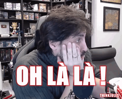 Man Sitting In Chair Hands On Face Saying Oh La La GIF