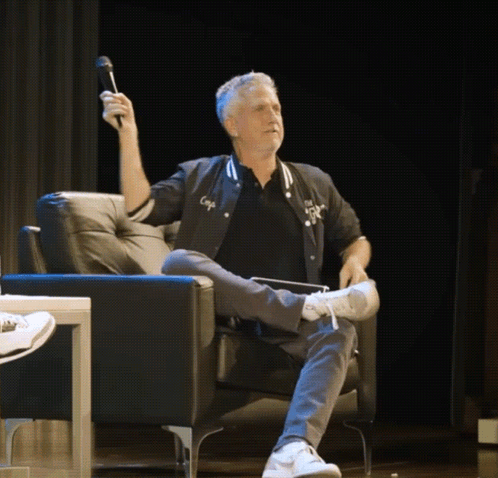 Man Sitting in Chair Holding Microphone