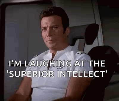 Man Sitting in Chair Laughing at Superior Intellect