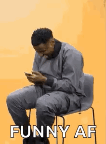 Man Sitting in Chair Looking at Phone Saying Funny AF