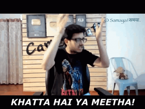 Man Sitting in Chair With Arms in Air Saying Khatta Hai Ya Meetha