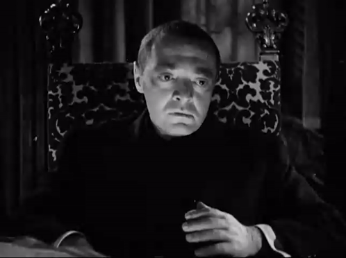 Man Sitting in Chair With Hands Folded