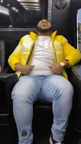Man Sitting in Chair with Yellow Jacket and Blue Jeans