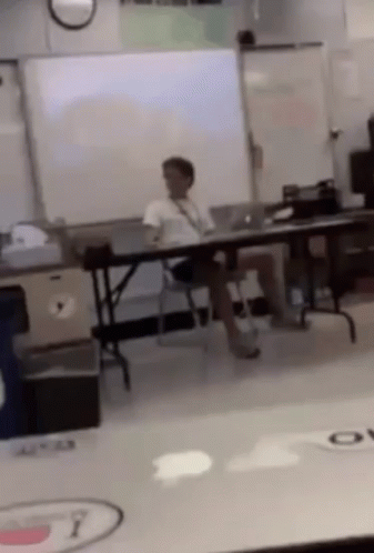 Man Sitting In Classroom With Legs Crossed GIF
