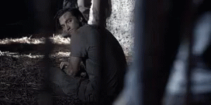 Man Sitting in Dark Room with Fence