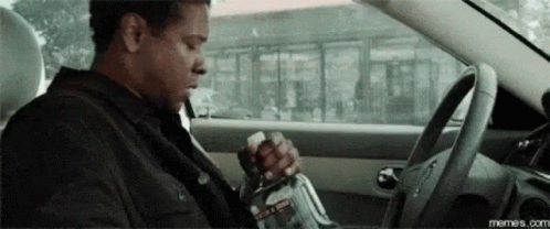 Man Sitting in Driver Seat Holding Bottle