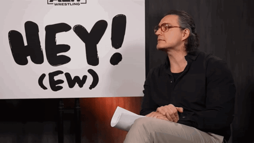 Man Sitting in Front of Hey Ew Sign