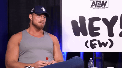Man Sitting in Front of Hey (Ew) Sign