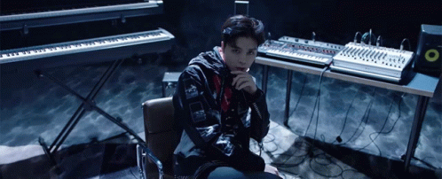 Man Sitting in Front of Keyboard and Mixer